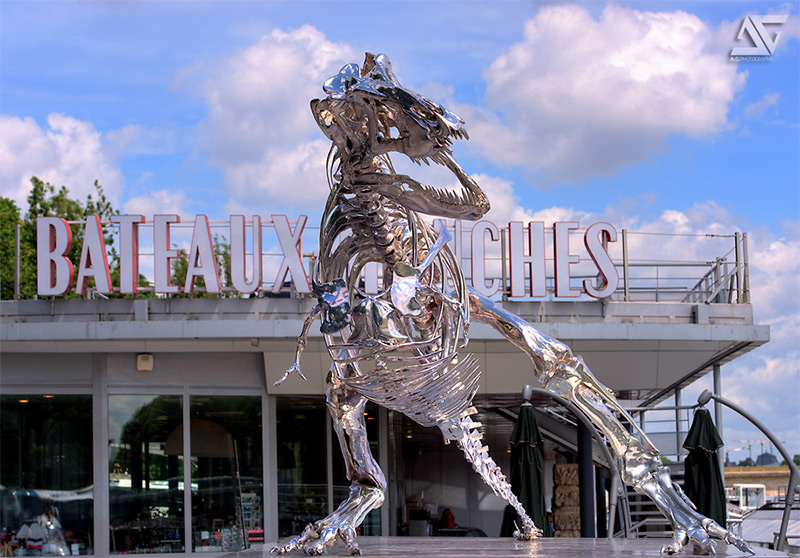 Illustration for article titled Incredible chrome T-rex skeleton scavenges on the banks of the Seine